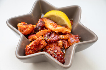 Tasty antipasti salad or starter seafood dish, grilled octopus spanish style with red paprika  served in restaurant