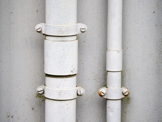 Close-up of White Metal Pipes on Gray Wall