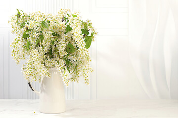 Abstract floral arrangement and banner for screen, Still life with beautiful spring branches of blooming bird cherry in vase on elegant background.Floral holiday card with summer greeting concept