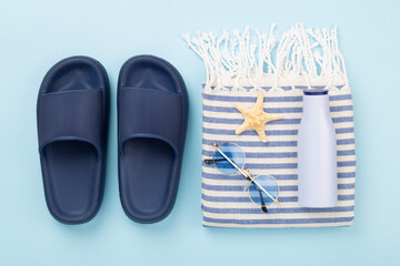 Beach towel with summer accessories on color background, top view