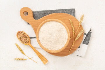 Bowl with spelt flour on concrete background, top view