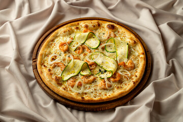 A beautifully crafted seafood pizza, adorned with tender shrimp and fresh zucchini slices, sits atop a polished wooden platter in a cozy, elegant restaurant