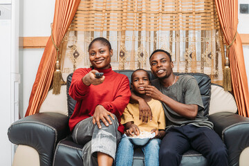 Happy Family Watching TV and Enjoying Snacks Together in Living Room