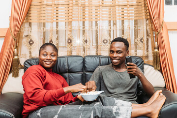 Smiling Friends Relaxing On Sofa Enjoying Entertainment Together