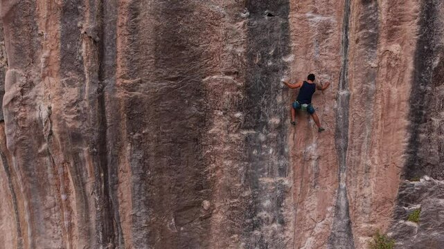 Escalada en la monta&ntilde;a, deporte extremo de aventura en el desierto, hombre escalando una pared natural 