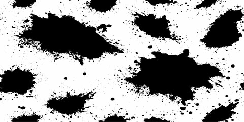 Black ink splatters and spots on a white background creating an abstract and texture dynamic ink. 