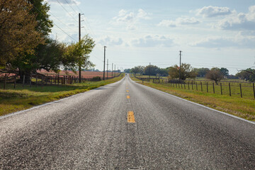 Low angle view of two lane asphalt highway in rural central Florida on a sunny afternoon