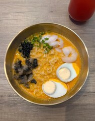 Appetizing ramen bowl with seafood and eggs