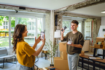 A woman is film a man hold cctv security camera and give instructions