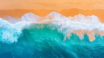 Selbstklebende Fototapeten Aerial view captures stunning turquoise ocean waves crashing onto the golden sandy beach coast. © SAN