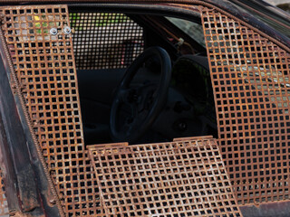 Abandoned Rusty Car with Metal Grate Windows