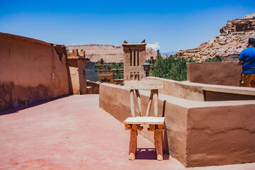 Traditional Moroccan kasbah architecture with wooden chair in desert village