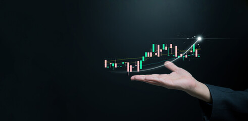 Business growth, economic development, or investment concept: A hand holding an upward trending line alongside a graph, symbolizing success, progress, and rising market performance