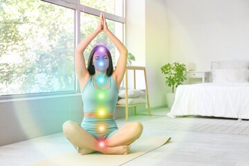 Morning of beautiful young woman with colorful aura doing yoga in bedroom