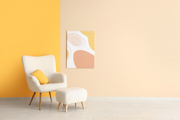 Fototapeta na wymiar White armchair, pouf and picture on colorful wall in room