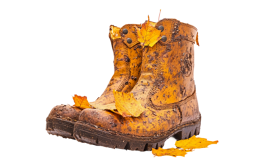 Pair of autumn boots with colorful fallen leaves stuck to the sole captured in a seasonal outdoor setting isolated on white background PNG