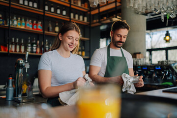 Bartenders polishing glasses in cozy pub, preparing for service
