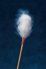 Close-up of a Cotton Swab on a Blue Background in Studio Lighting for Medical and Personal Care Use