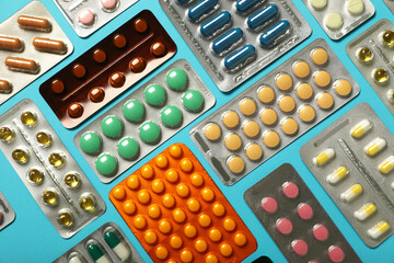 Different pills in blister packs on blue background