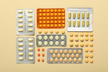 Different pills in blister packs on beige background