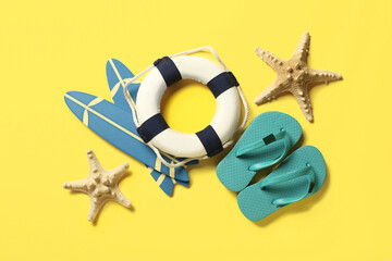 Composition with mini beach accessories and starfishes on yellow background