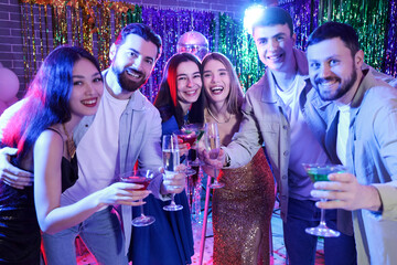 Young people with drinks at party in night club