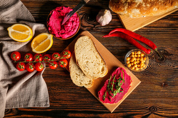 Composition with tasty beetroot hummus, ingredients and fresh bread on wooden background