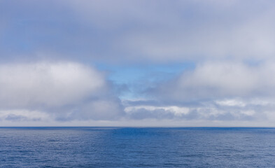 Serene Ocean View With Clouds and Blue Sky Over Pacific Waters