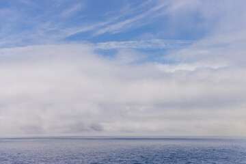 Tranquil Cloudy Sky Over a Serene Blue Ocean Horizon