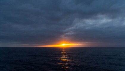 Dramatic Sunset Over Moody Ocean Horizon Beneath Stunning Cloudscape