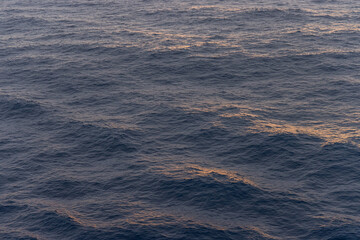 Serene Ocean Waves With Sunlit Reflections During Twilight Hours