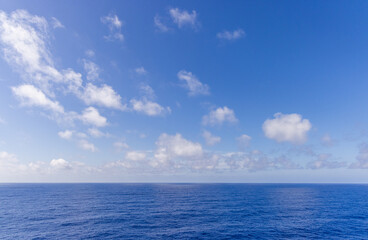 Wide View of Blue Ocean and White Clouds Under a Sunny Sky