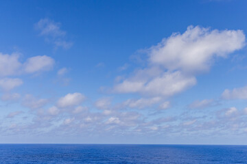 Fototapeta premium Blue Ocean With Clouds Under a Clear Sky Over the Pacific Ocean