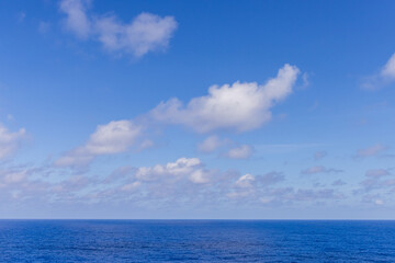 Serene Blue Ocean Under Clear Sky with Light Clouds
