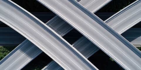 Obraz premium Highways crisscross in an intricate network over green foliage. Urban infrastructure, complexity