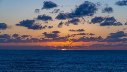 Serene Sunset Over Pacific Ocean with Scenic Clouds and Tranquil Water Surface