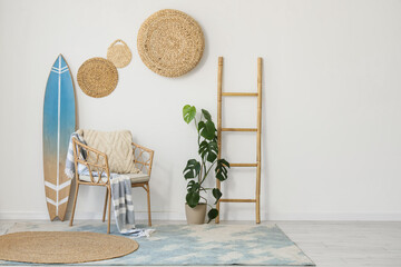 Interior of light room with surfboard, armchair and ladder