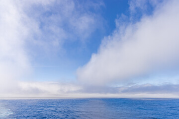 Serene Ocean Scene With Blue Sky and Fluffy Cloud Formations