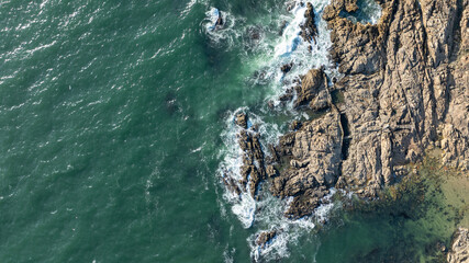 Rebentamento de ondas em rochas na costa.