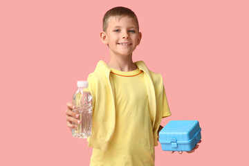 Little boy with lunchbox and water bottle on pink background