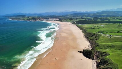Experience a breathtaking panoramic aerial view of a scenic beach on a beautiful sunny day