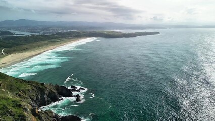 Stunning Coastal Aerial View Capturing the Waves Gently Crashing on the Sandy Beach