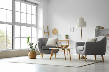 Comfortable armchairs and wooden coffee table in interior of room