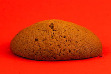 Brown round baked good sits on a bold red background