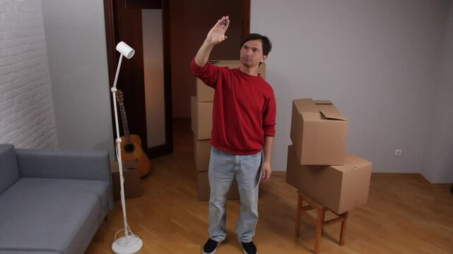 Happy man showing keys of new apartment after moving in