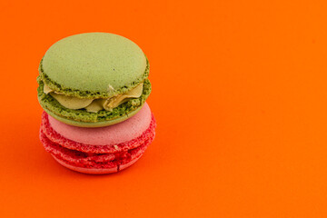 Colorful macaron stack on bright orange background