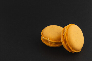 Delicious yellow macarons on a dark background