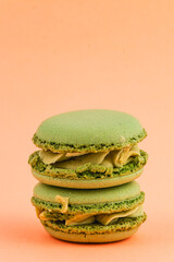 Green macarons stacked delightfully against a peach background