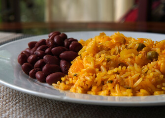 Yellow rice with tuna and red beans on a glass table, typical Costa Rican food
