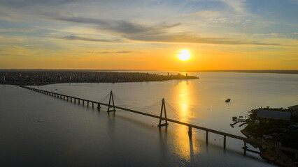Obraz premium Wide aerial view of Posadas and the International Bridge at sunset over the Paraná River.
